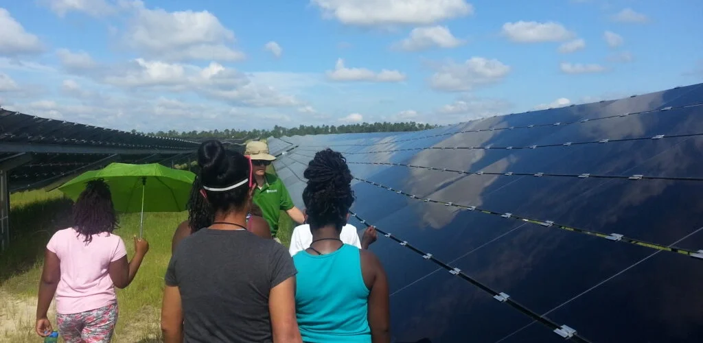 Youth walk during a tour of a solar farm.